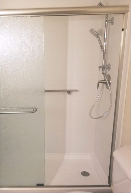 Inside of walk-in shower with adjustable handshower