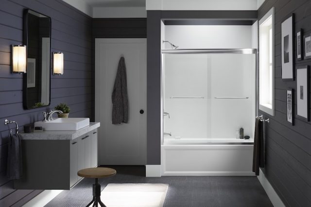 Bathroom with navy blue walls and white shower with glass door