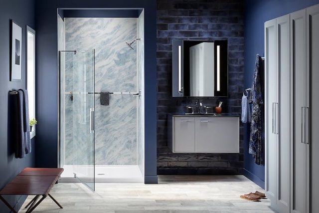 Blue bathroom with glass shower door open'