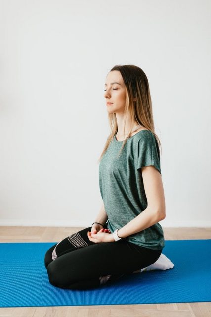 Woman sitting on Yoga mat