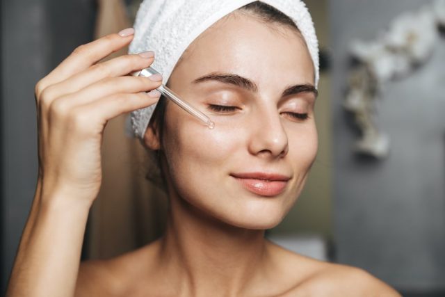 Woman applies cleansing oil to her face