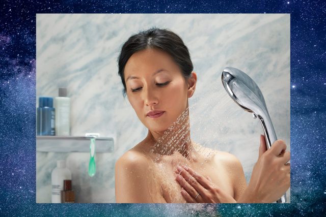 Woman using handshower with galaxy background'