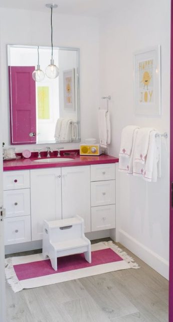 Magenta pink kids' bathroom with step stool and towel storage