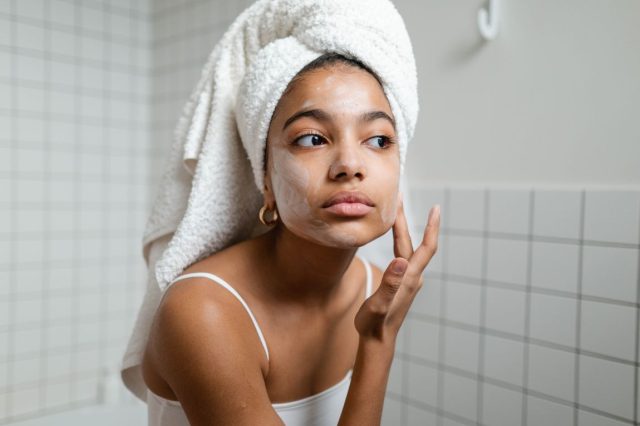 woman moisturizing in bathroom'