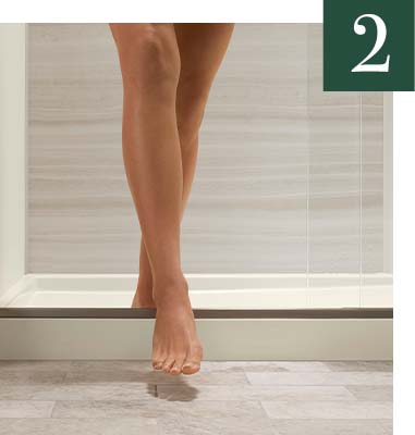 Woman stepping over low-threshold shower base