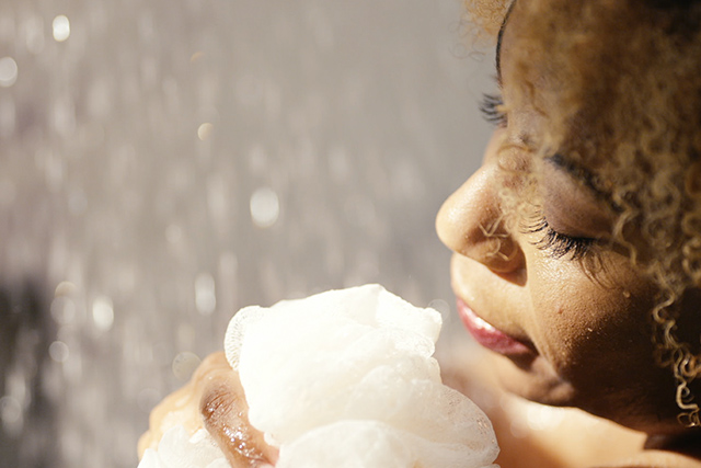 Woman washing body with loofah