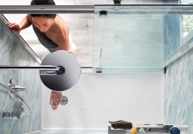 woman checking temperature of shower water'