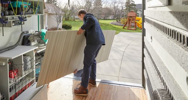 Installers unloading shower walls off truck at homeowners house