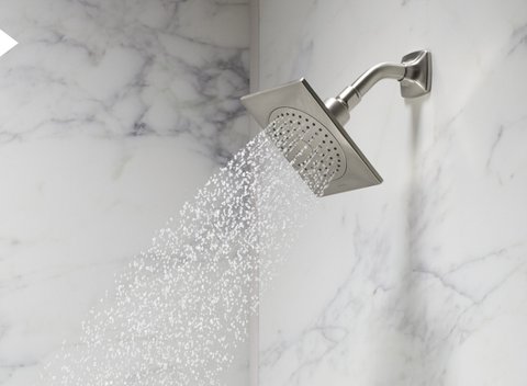 close up of shower head spraying water